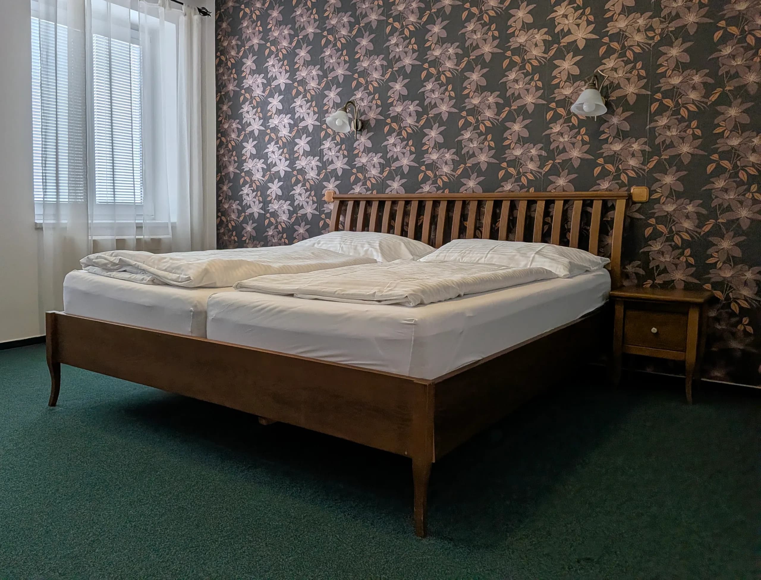Hotel U Labutě — a historic room with floral wallpaper